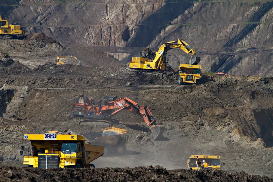 Excavators and haul trucks working in an open-pit mine